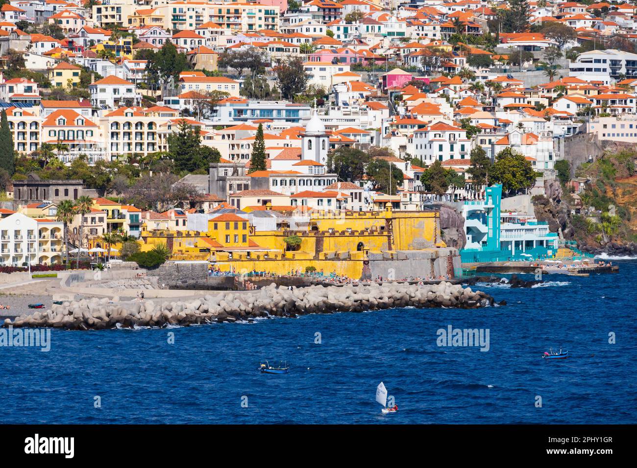 Die senffarbene, gelb bemalte Festung Sao Tiago der Hauptstadt Funchal, Madeira, Portugal, vom Meer aus gesehen. Stockfoto