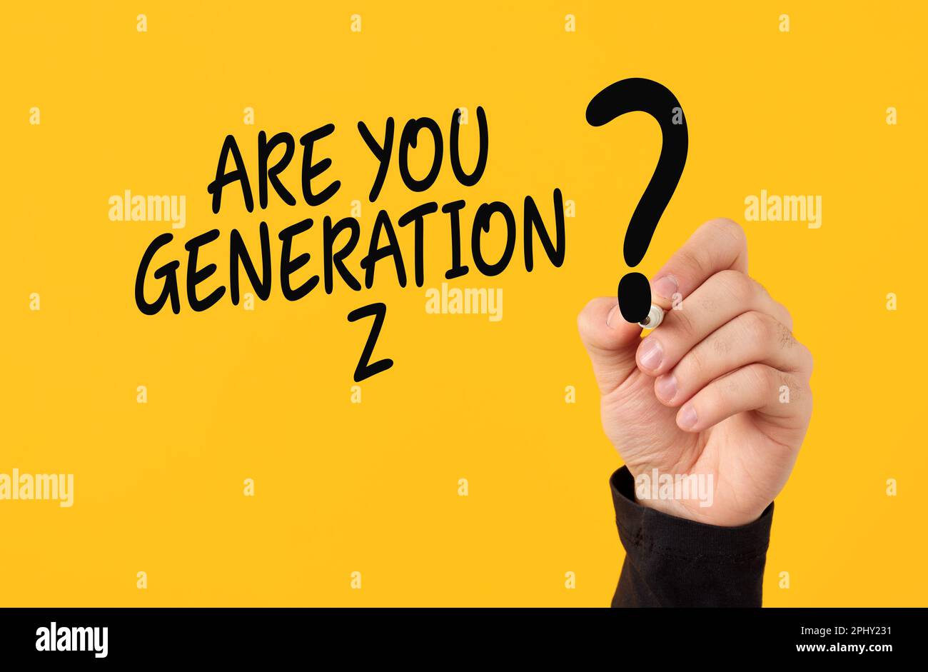 Konzept der Z-Generation. Männliche Hand zeichnet ein Fragezeichen mit der Frage, ob Sie Generation z sind, auf gelbem Hintergrund. Stockfoto