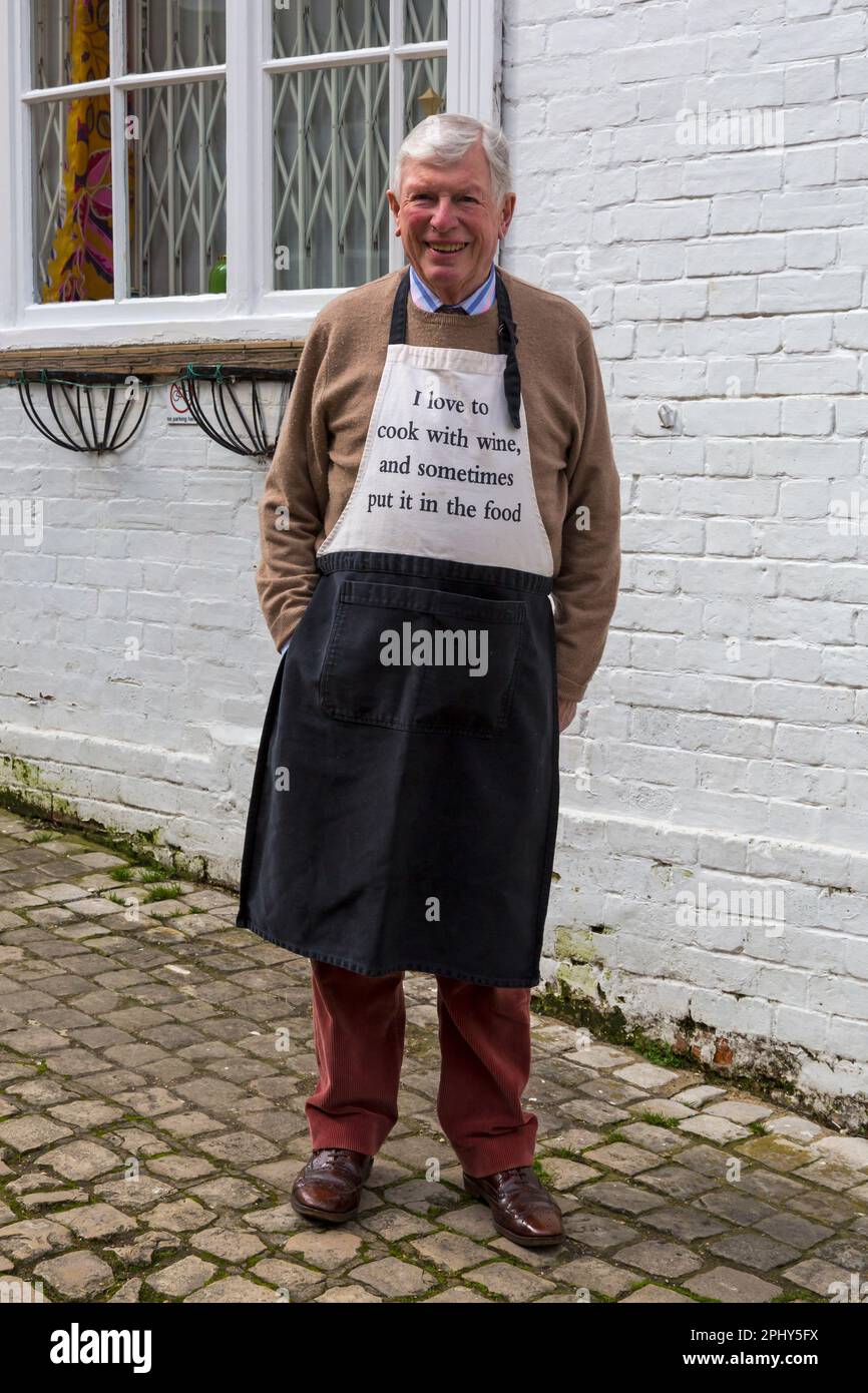 Mann trägt ich liebe es, mit Wein zu kochen und manchmal im März in meiner Schürze in Lymington, Hampshire, Großbritannien Stockfoto