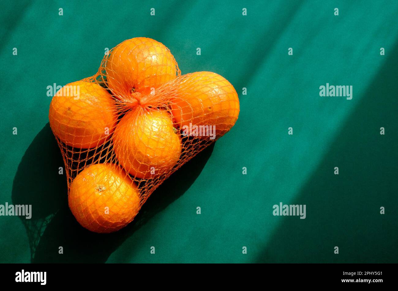Beutel mit fünf Orangen auf grünem Hintergrund Stockfoto
