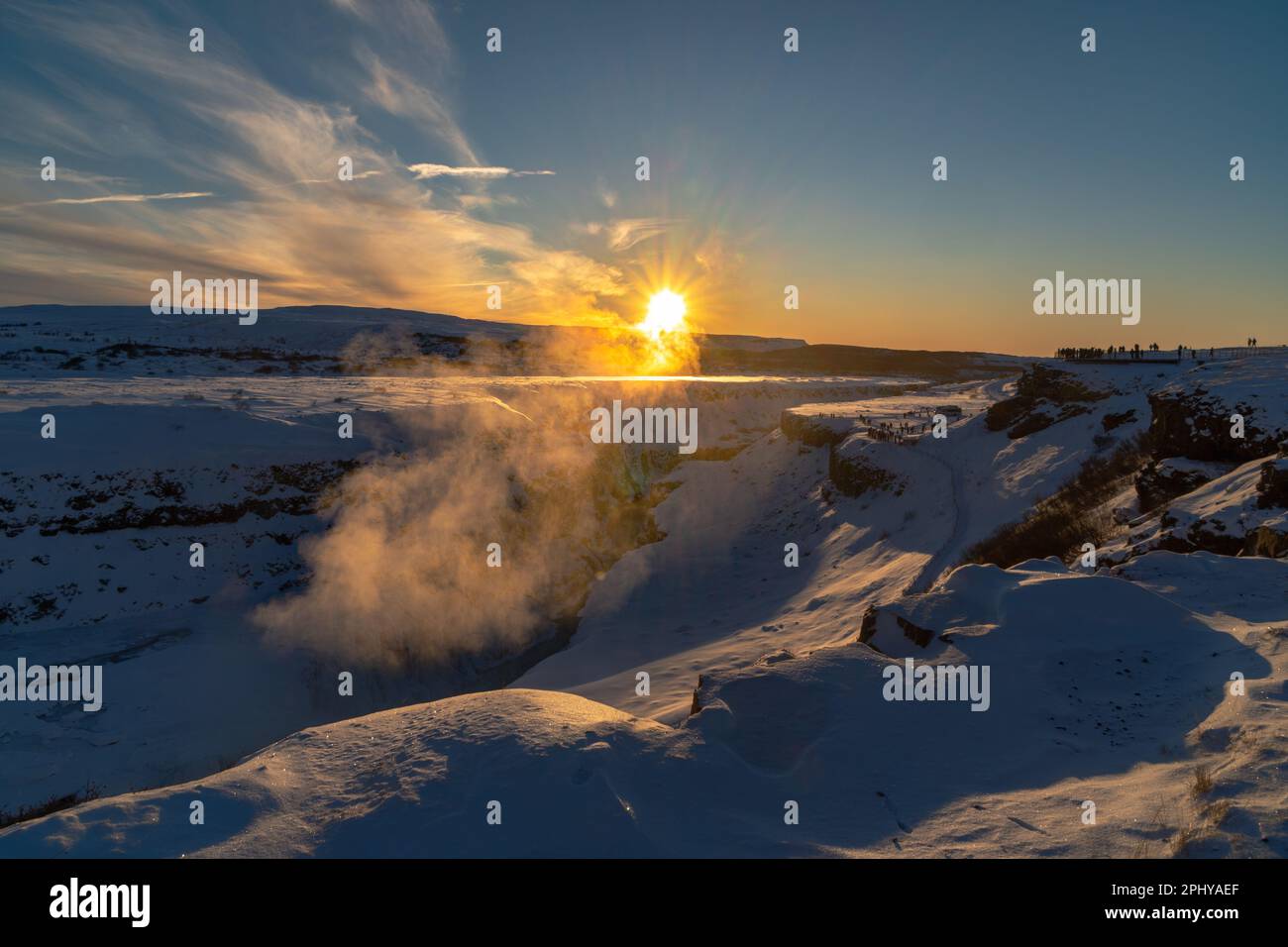 Der doppelte Wasserfall von Gullfoss, geformt durch den Bruch der tektonischen Platten, beleuchtet durch die ersten Strahlen der Morgensonne, die den Nebel erhellen Stockfoto
