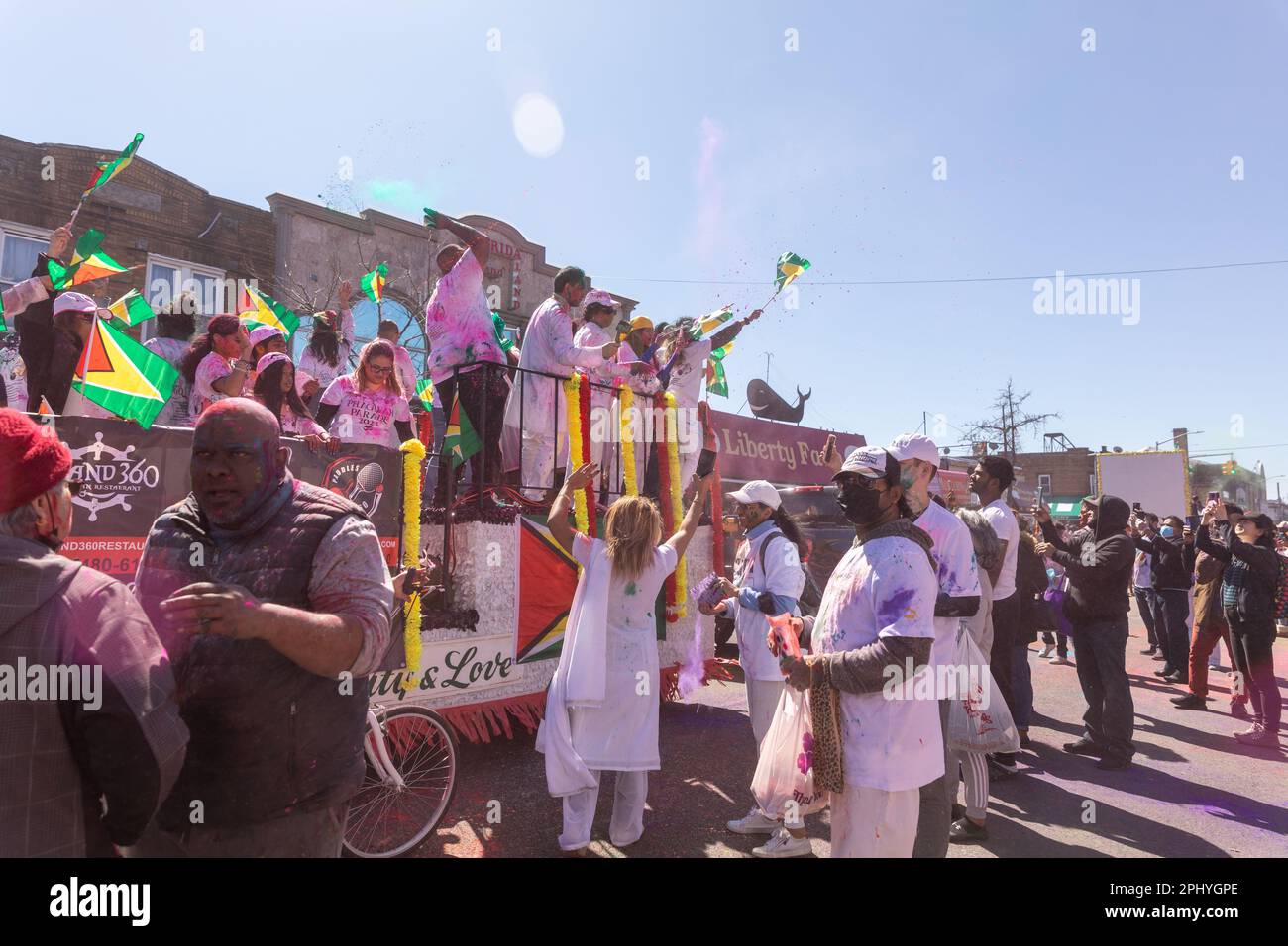 Eine Gruppe von Menschen, die bei der Phagwah Holi Parade 2023 in Queens, NY, Farbpulver auf sich verteilen Stockfoto