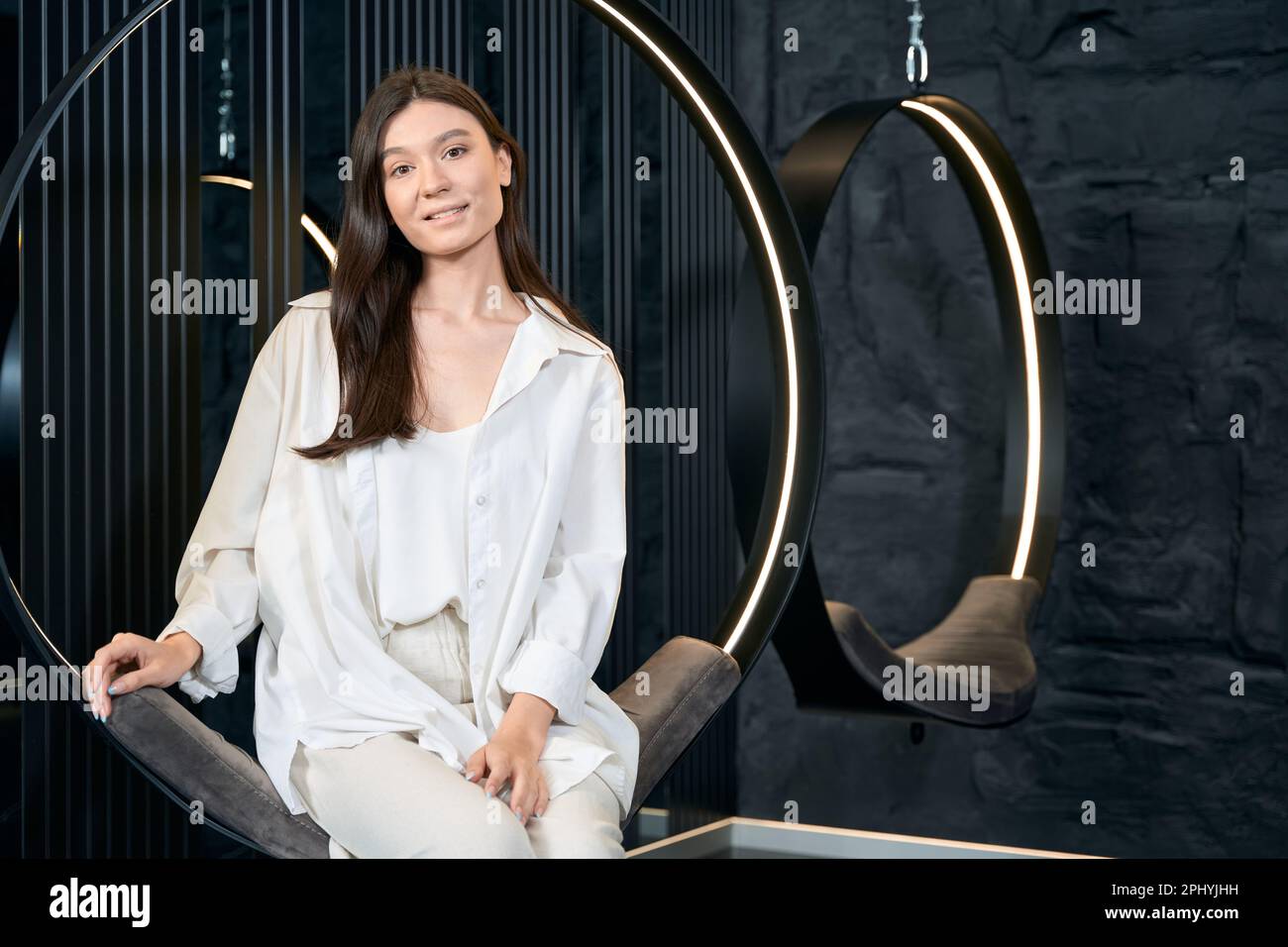 Lady sitzt auf einem Hängestuhl in der Schönheitsklinik Stockfoto