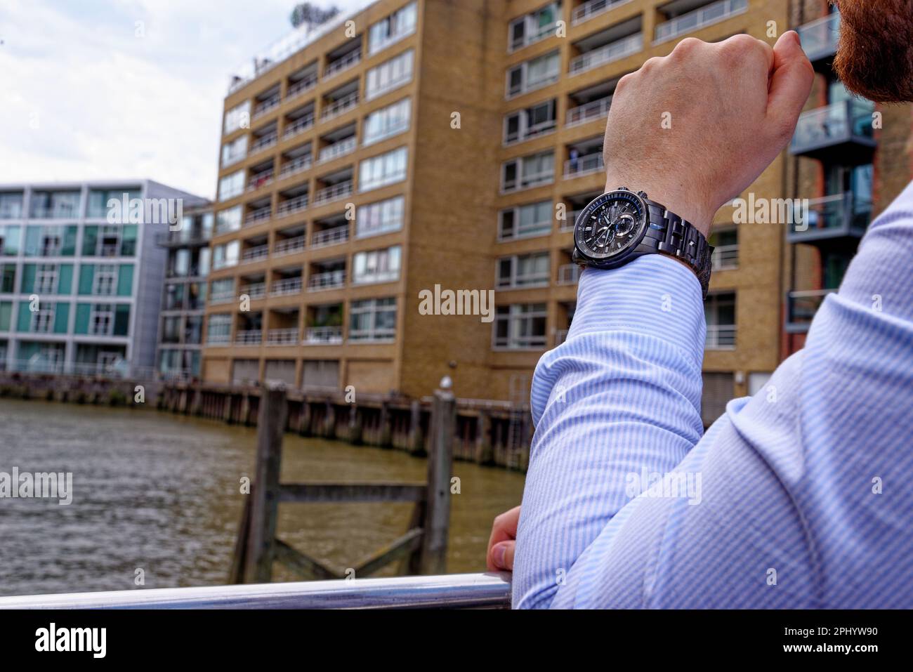 Junger Mann in China Wharf London trägt Moduhr - London, Großbritannien, 1. Juni 2019 Stockfoto