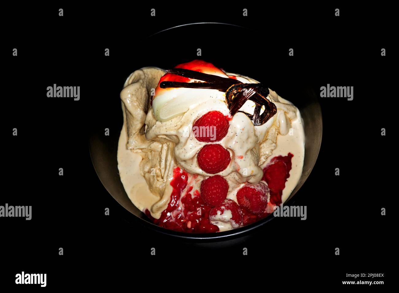 Vanilleeis mit frischer Mauritius-Vanille, Himbeeren, geknüpfter Vanillebohne und halbiertem japanischem Mochi-Eis, Lebensmittelfotografie mit einem Stockfoto
