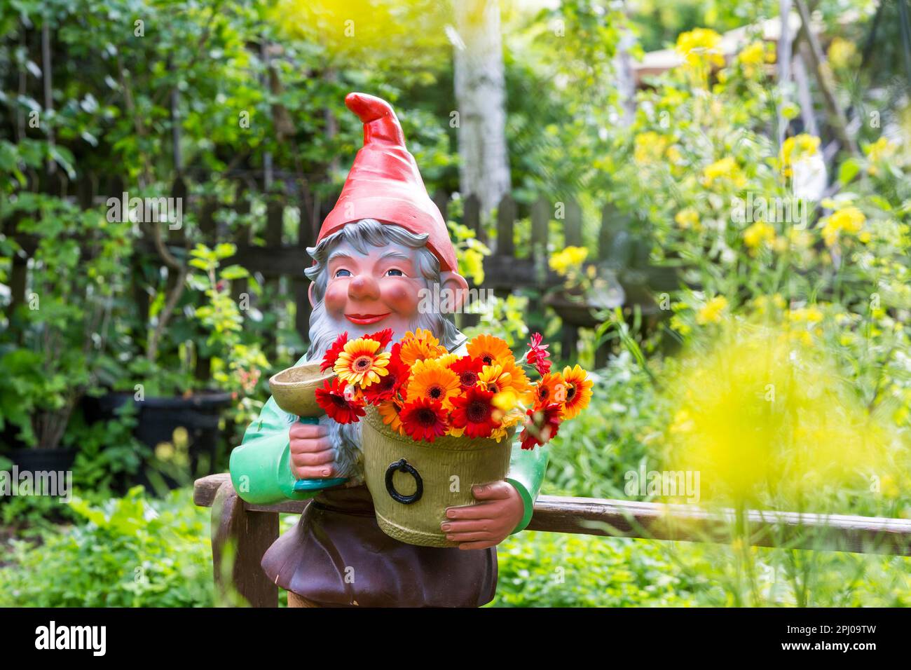 Großer Gartenzwerg mit Blumen in einem Garten, Muensingen, Baden-Württemberg, Deutschland Stockfoto