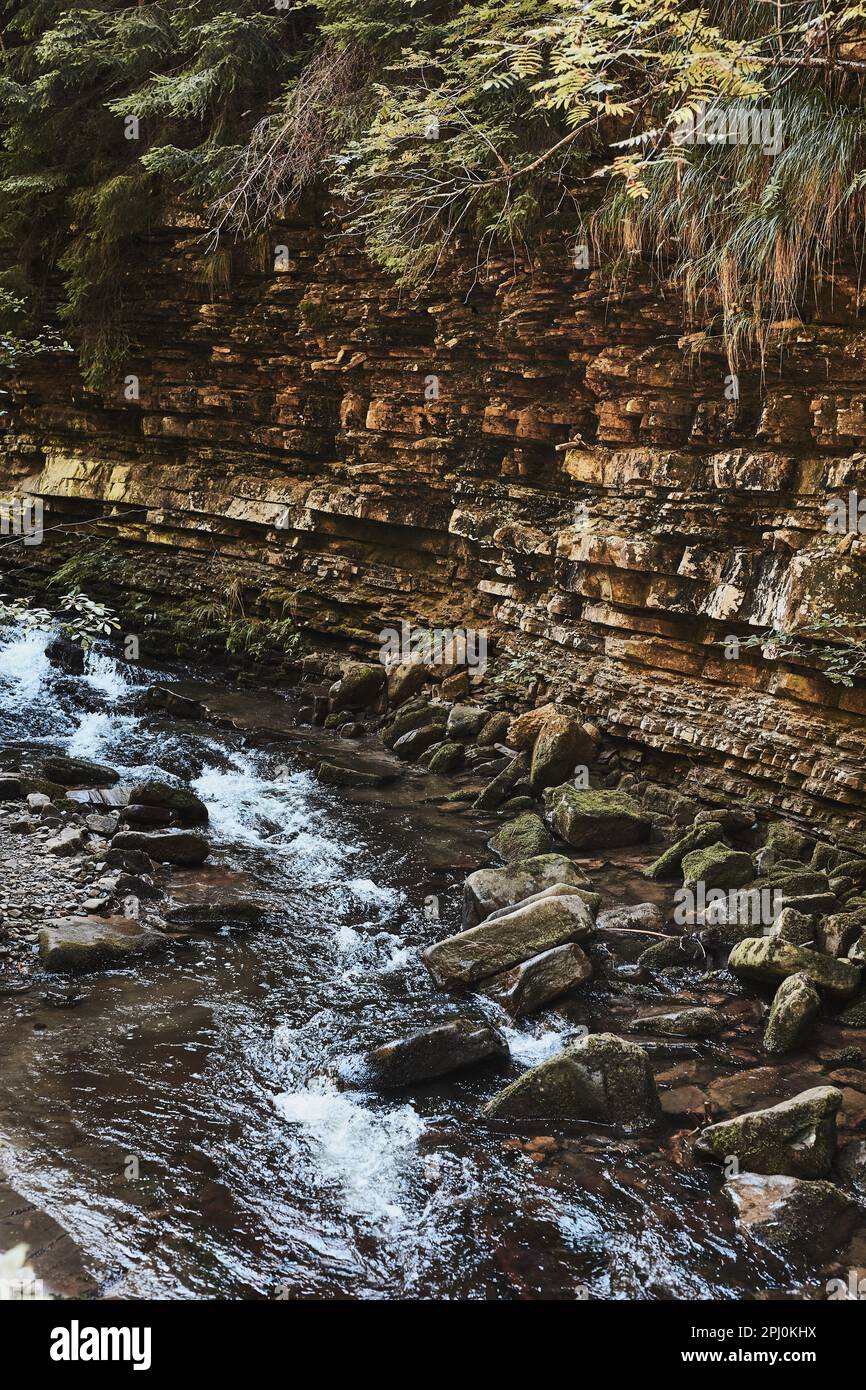 Bergbach fließt an der felsigen Wand hinunter. Berglandschaft. Natürliche Szene. Schönheit in der Natur Stockfoto