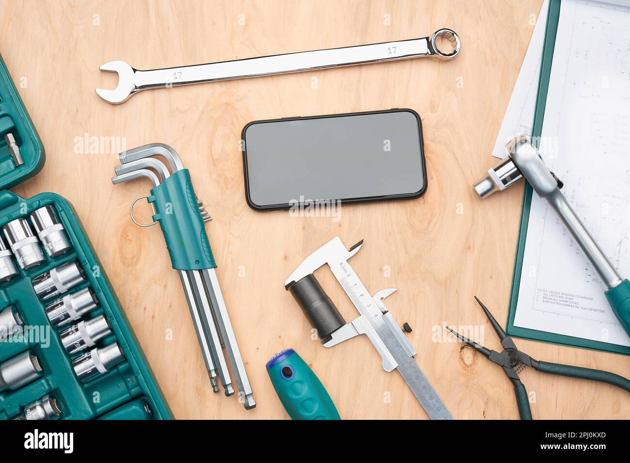 Werkstatttisch mit vielen Werkzeugen. Schraubenschlüssel, Schraubenschlüssel, Bremssattel und Ratsche mit vielen Aufsätzen. Arbeitswerkzeuge. Universeller Werkzeugsatz. Professionelle Ausrüstung. B Stockfoto