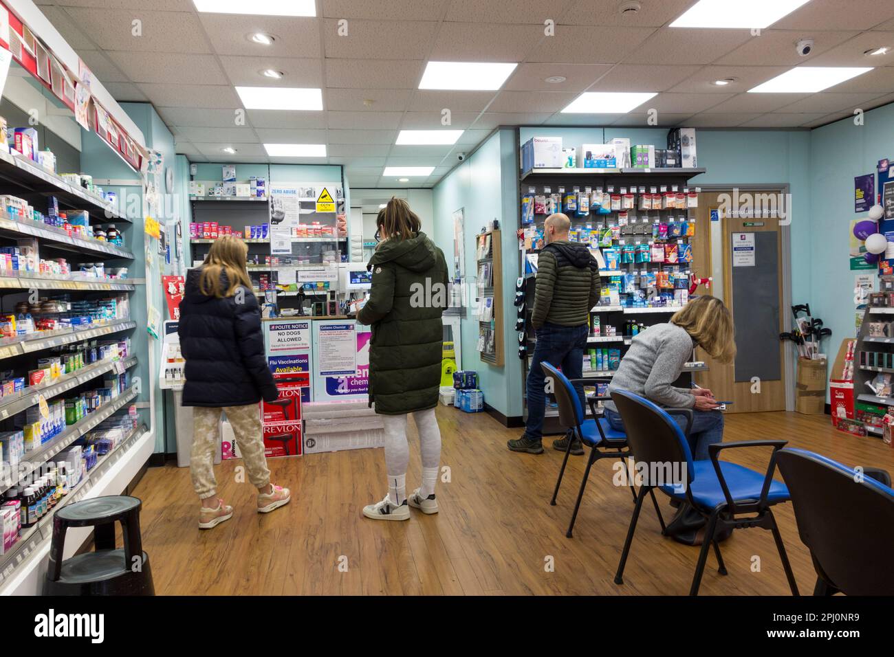 Kunden in der Schlange innerhalb des Apothekers, Großbritannien Stockfoto