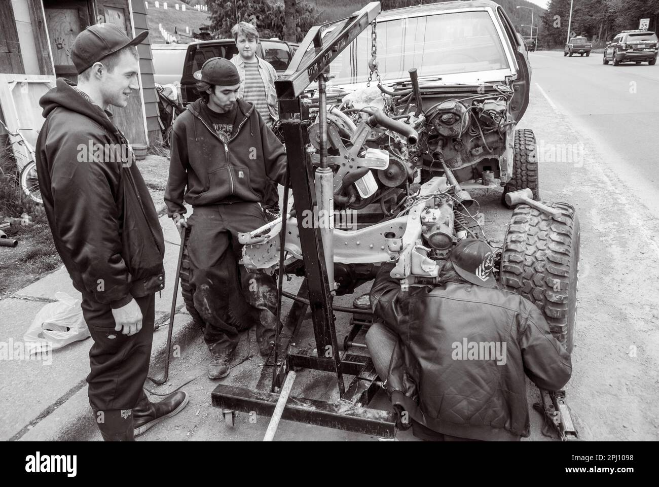 Shade Tree Street Mechaniker installieren Motor in altem junker-Auto in Sitka, Alaska, USA. Stockfoto