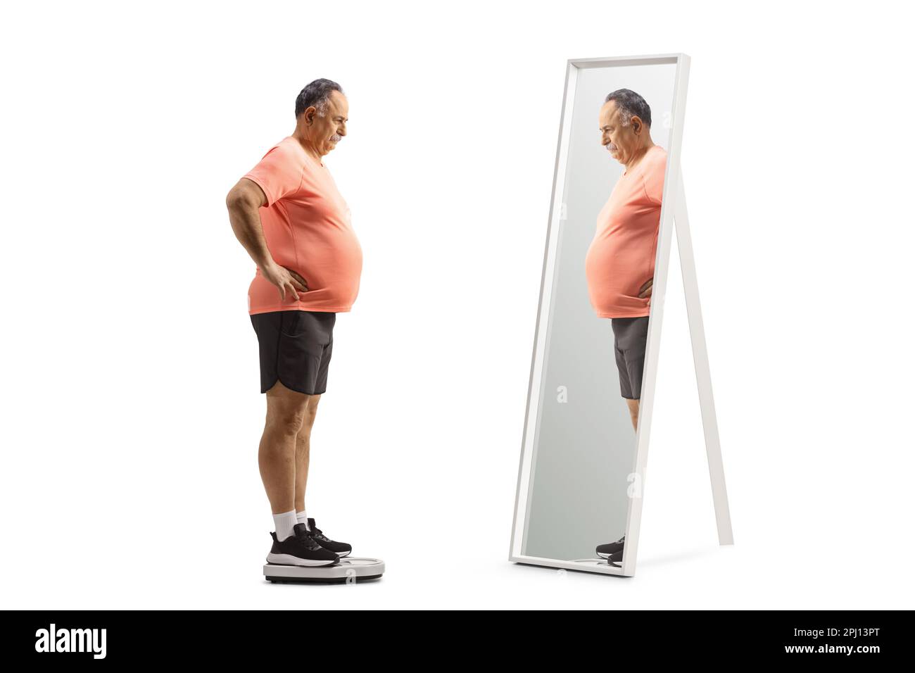 Ein erwachsener Mann mit einem großen Bauch, der auf einer Waage steht und auf einen Spiegel auf weißem Hintergrund schaut Stockfoto