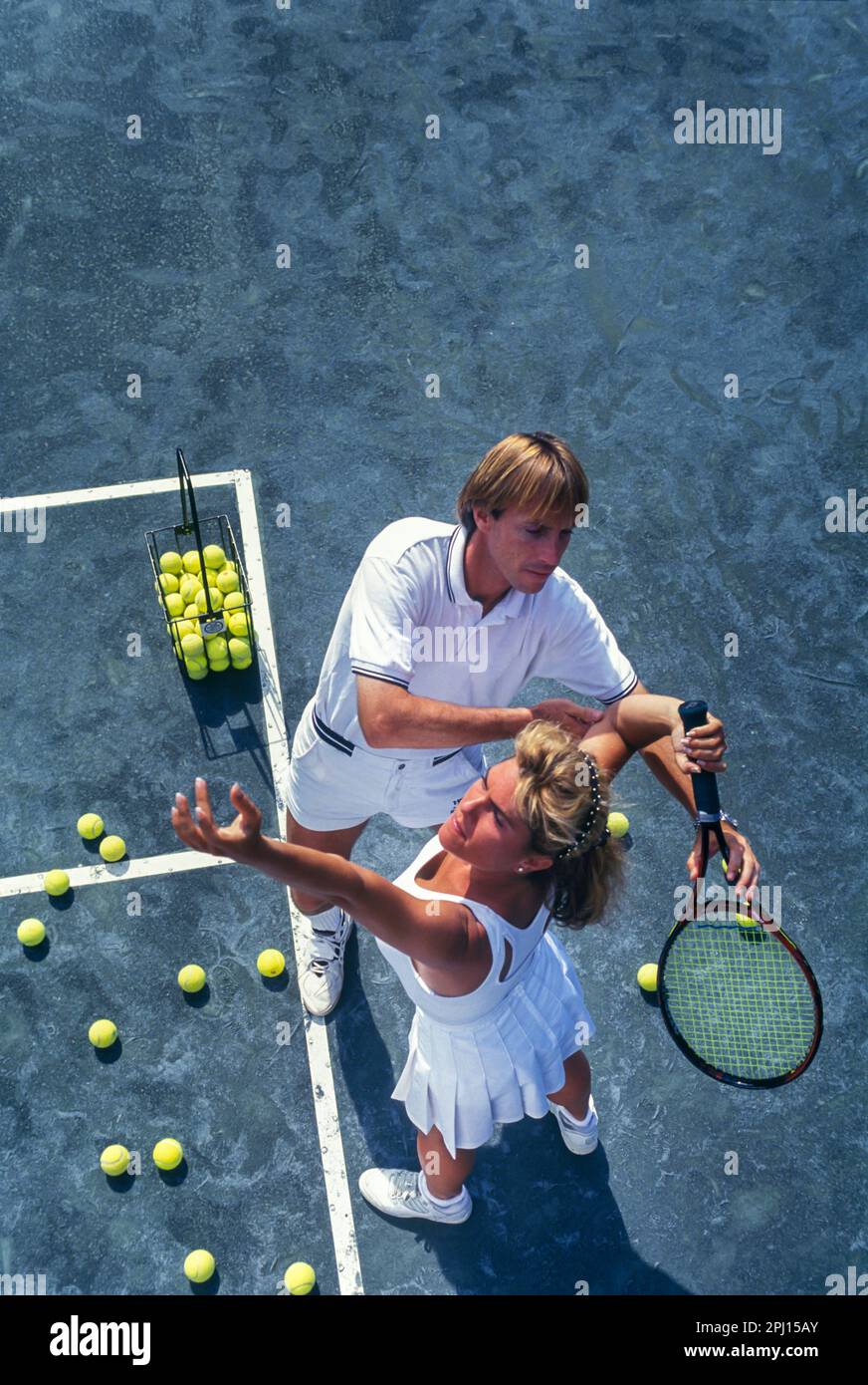 TENNISSPIELERIN MIT PERSONAL TRAINER AUF SANDTENNISPLATZ Stockfoto