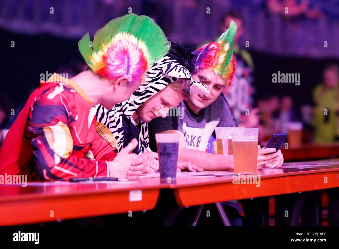 Berlin, Deutschland. 30. März 2023. Dart: Premiere League, 9. Spieltag in der Mercedes-Benz Arena. Fans mit bunten Perücken bereiten sich auf den Spieltag in der Mercedes-Benz Arena vor. Kredit: Jean-Marc Wiesner/dpa/Alamy Live News Stockfoto