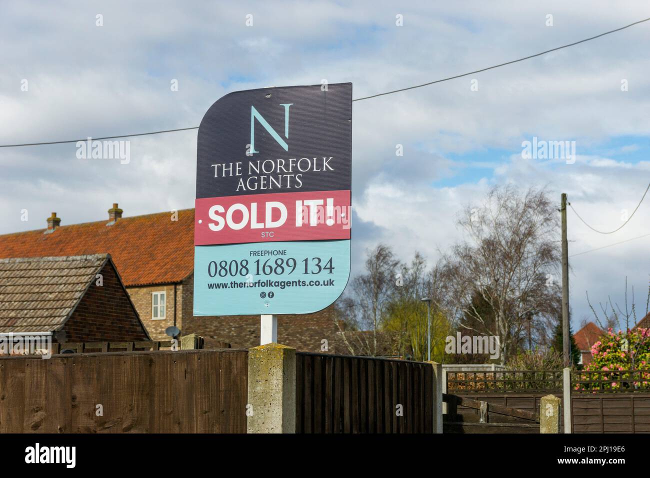 Verkauft! unterschreiben Sie vor einem Haus in Norfolk auf dem Board eines Maklers zum Verkauf. Stockfoto