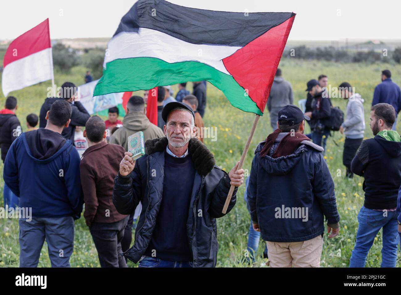 Ein palästinensischer Protestteilnehmer schwenkt während eines Protests, der an der Grenze zwischen Israel und dem Gazastreifen im Osten des Gazastreifens als "Landtag" gekennzeichnet ist, mit einer palästinensischen Flagge. Der "Landtag" erinnert an die Ereignisse vom 30. März 1976, als in arabischen Städten Märsche und ein Generalstreik gegen die Entscheidung der israelischen Regierung organisiert wurden, große Teile palästinensischen Landes zur Siedlung zu enteignen. Die jährliche Veranstaltung fordert das palästinensische Recht auf Rückkehr in das Land, aus dem sie nach der Gründung Israels im Jahr 1948 vertrieben wurden. Stockfoto