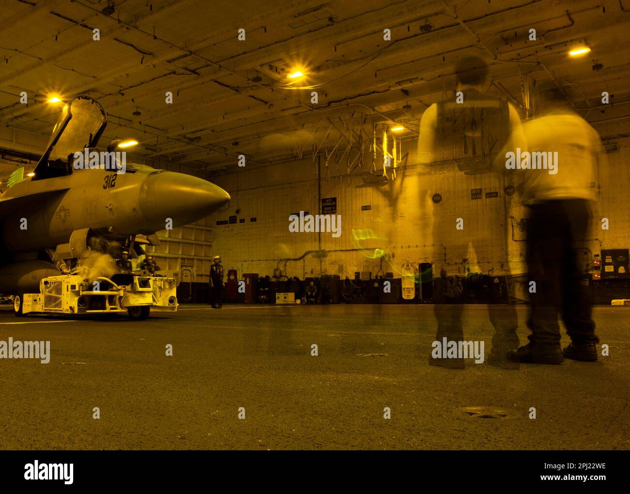 Matrosen, die dem erstklassigen Flugzeugträger USS Gerald R. Ford (CVN 78) zugeteilt sind, führen mit einem Spürhütchen eine F/A-18E Super Hornet, die an den „Tomcatters“ der Streikfighter-Staffel (VFA) 31 befestigt ist, durch die Hangarbucht des Schiffes am 24. März 2023. Ford ist im Atlantik dabei, seine Composite Training Unit Exercise (COMPTUEX) durchzuführen, eine intensive, mehrwöchige Übung, die darauf abzielt, eine Trägerstreikgruppe als zusammenhängende, multimissionale Kampftruppe vollständig zu integrieren und ihre Fähigkeit zur Durchführung nachhaltiger Kampfoperationen vom Meer aus zu testen. Als das erste Schiff der Ford-Klasse Stockfoto