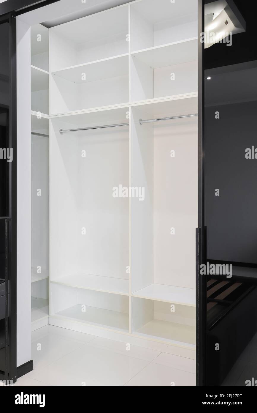 Offener weißer Kleiderschrank mit Regalen im Zimmer Stockfoto