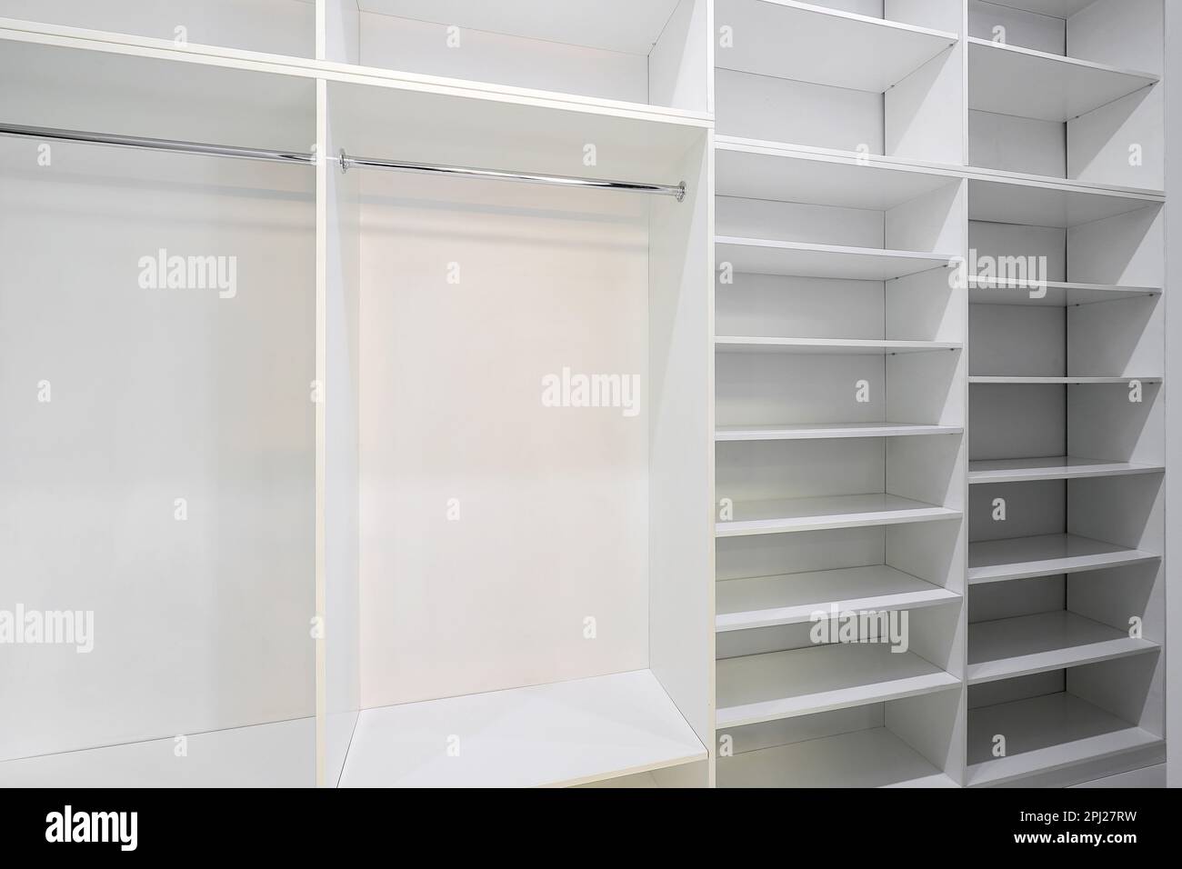 Offener weißer Kleiderschrank mit Regalen im Zimmer Stockfoto