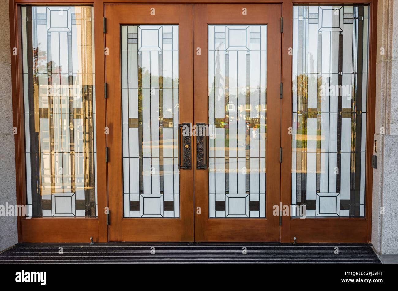 Fleckglastür. Vordereingang eines traditionellen Hauses mit einer Tür aus Buntholz im Missionsstil. Vordertür aus Glas. Niemand, selektiver Fokus, Straßenfoto Stockfoto