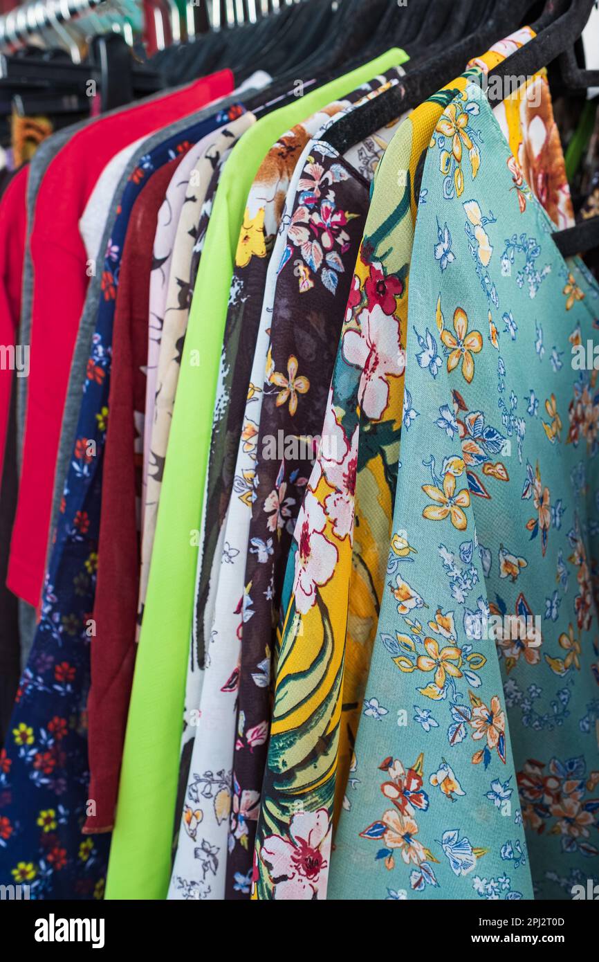 Frauenkleidung auf Kleiderständer. Modische Kleidung in einem Boutique-Laden. Helle, farbenfrohe Auswahl an Kleiderschränken. Niemand, selektiver Fokus Stockfoto