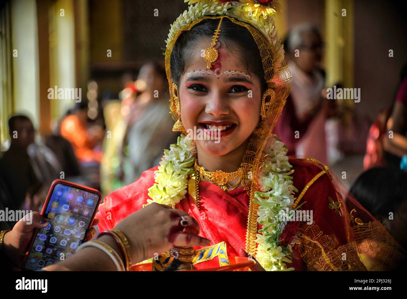 Ein Mädchen mit lächelndem Gesicht nimmt am Kumari-Puja-Ritual Teil. Kumari Puja ist eine indische hinduistische Tradition, die hauptsächlich während der Durga Puja/Basanti Puja/Navratri nach Hindu-Kalender gefeiert wird. Kumari beschreibt tatsächlich ein junges Mädchen im Alter von 1 bis 16 Jahren, das während des Übergangs von Ashtami/Navami tithi von Durga Puja/Navarintosh nach Hindu-Mythologie verehrt wird. Junge Mädchen, die während des Kumari Puja von ihren Müttern im Adyapith Tempel verehrt wurden, wird angenommen, dass Kumari Puja den Gläubigen und auch dem kleinen Mädchen viele Segen gewährt. Devotieren Stockfoto