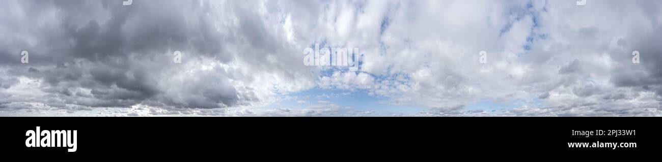 Blauer Himmel mit dunklen, wunderschönen Wolken vor dem Sturm. Panoramablick auf den bedeckten Himmel. Stockfoto