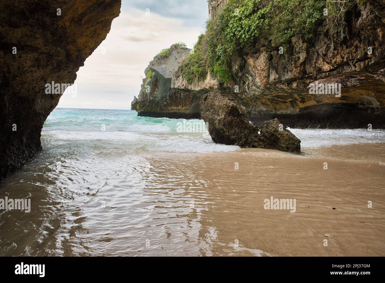 Der sulubanische Strand in Bali, Indonesien, umgeben von einer Bucht mit majestätischen Felsen. Stockfoto