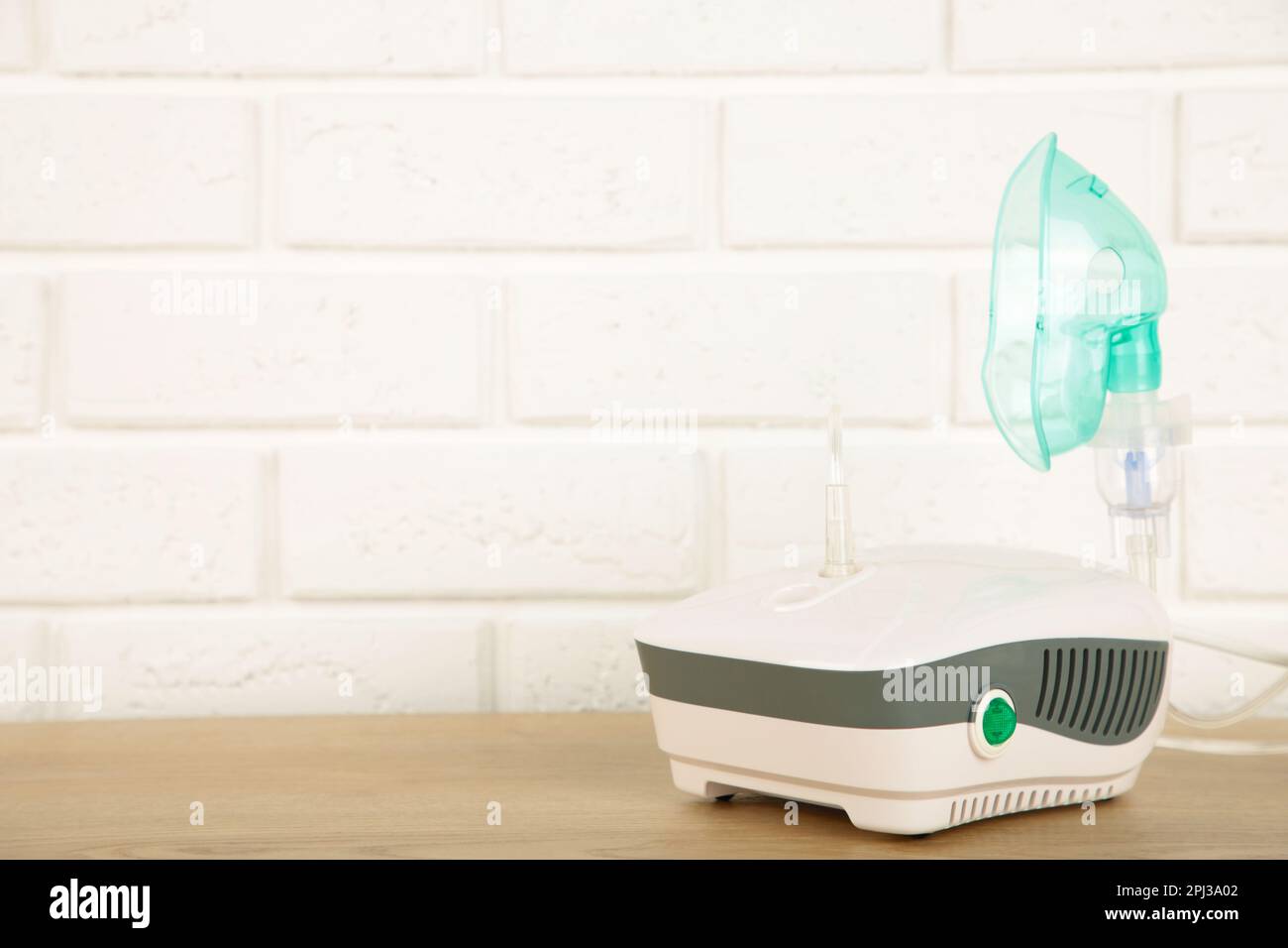 Vernebler mit Maske auf dem Tisch mit Kopierbereich. Stockfoto