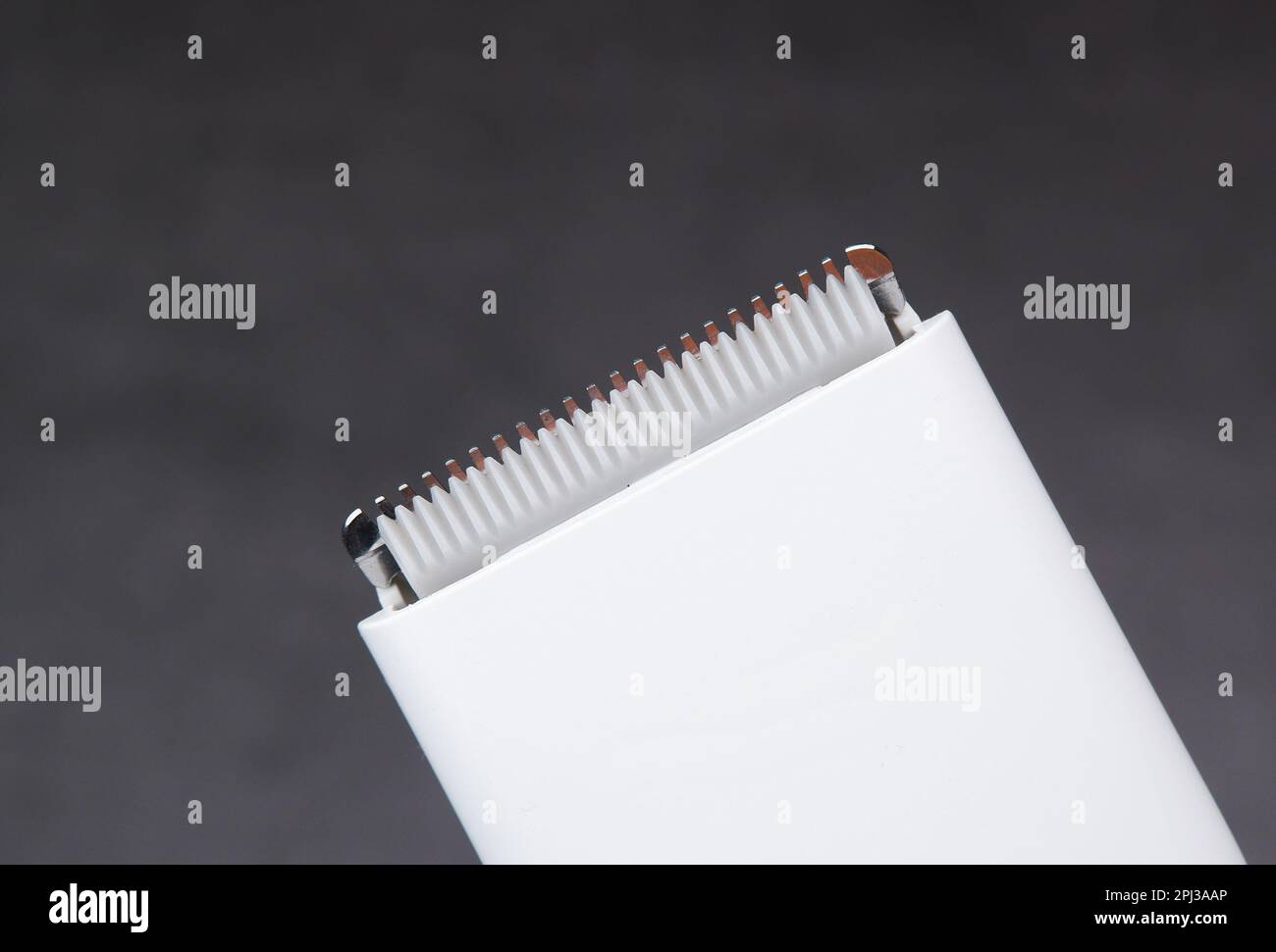 Nahaufnahme-Makro der keramischen Schneideklinge eines weißen Haarschneiders, Objekt auf dunklem Hintergrund isoliert. Stockfoto