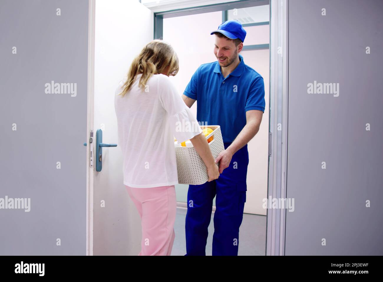 Liefermann, Der Der Frau Eine Plastikbox Schenkt Stockfoto