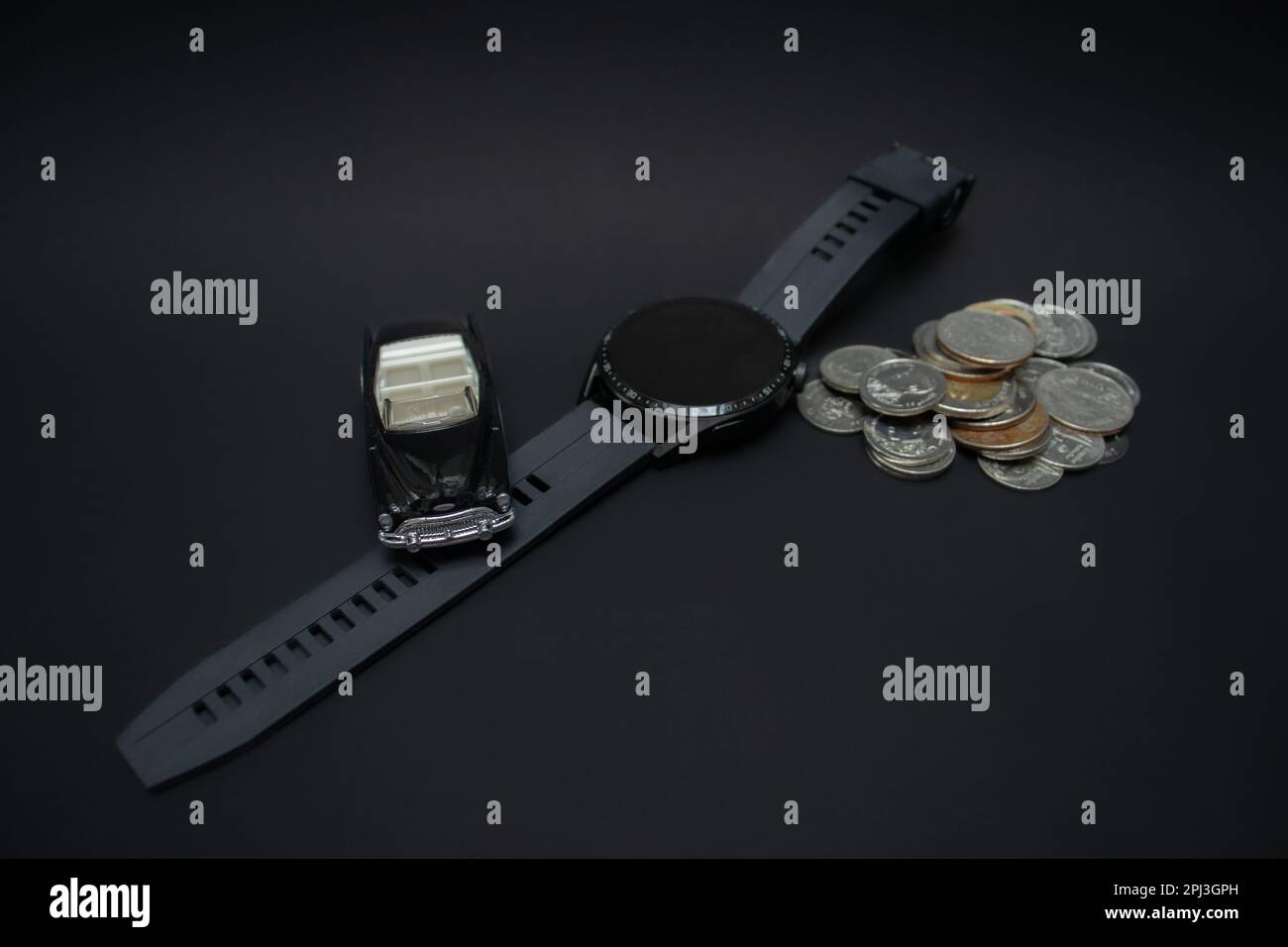 Konzept für Wohlstand und Finanzplanung. Ein Foto von einem Auto, einer Smartwatch und einem Haufen Münzen, nach einigen Änderungen. Stockfoto