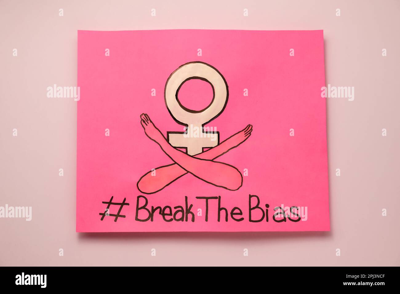 Karte mit Hashtag BreakTheBias, weibliches Geschlechtssymbol und Zeichnung der gekreuzten Arme auf pinkfarbenem Hintergrund, Draufsicht Stockfoto