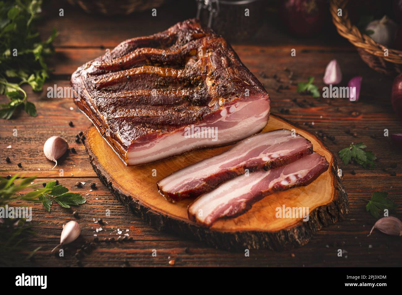 Trockengepökelter Schweinebauch mit Gewürzen auf Holzbrett Stockfoto