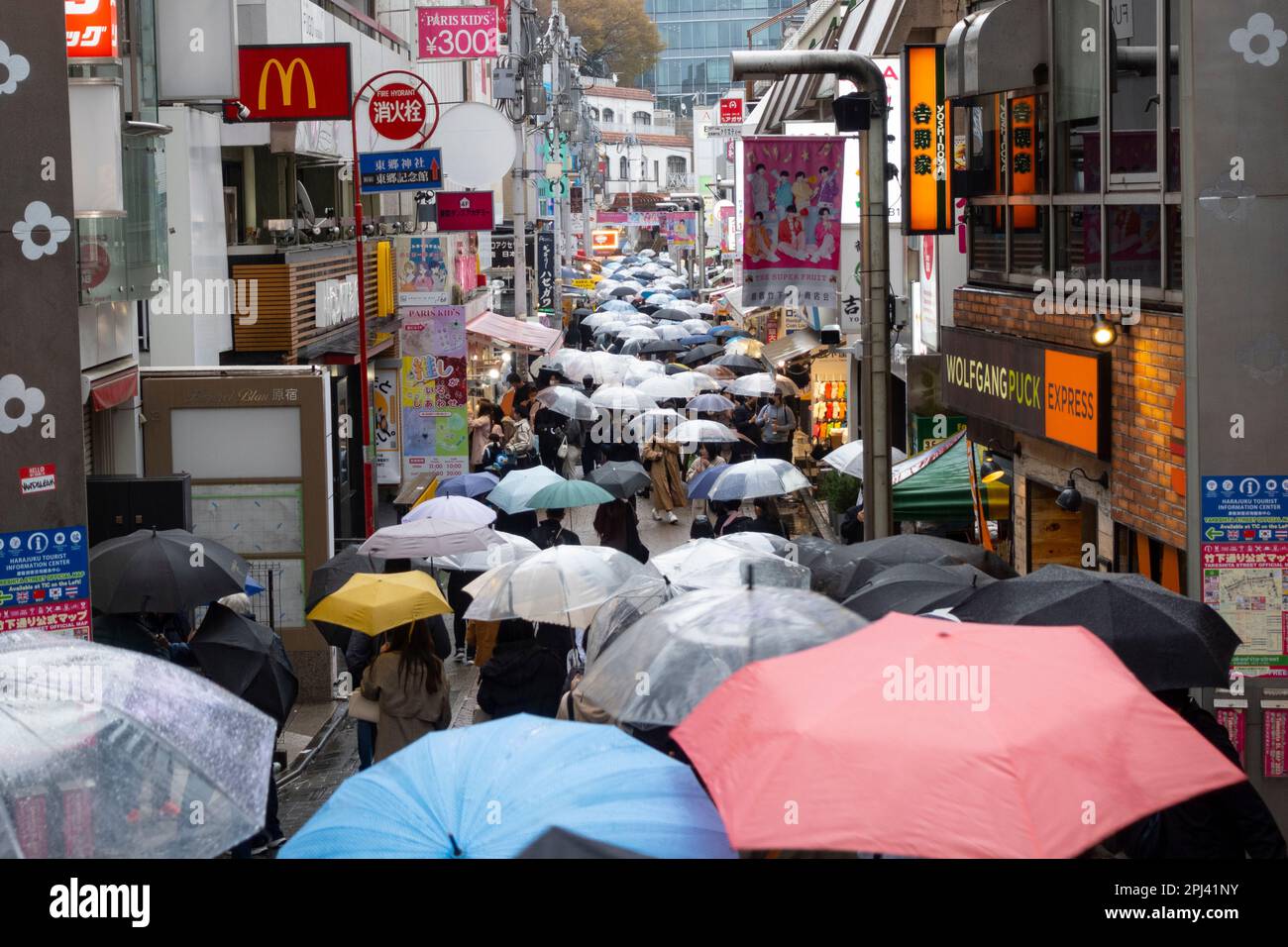 Sehen Sie die Takeshita Street mit vielen Sonnenschirmen im Regen in Harajuku, Tokio, Japan Stockfoto