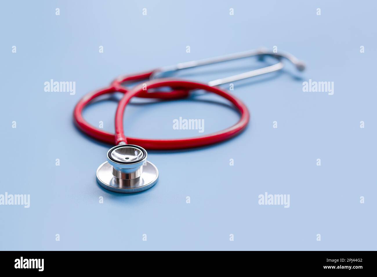 Rotes Stethoskop auf blauem Hintergrund, Gesundheitskonzept. Stockfoto