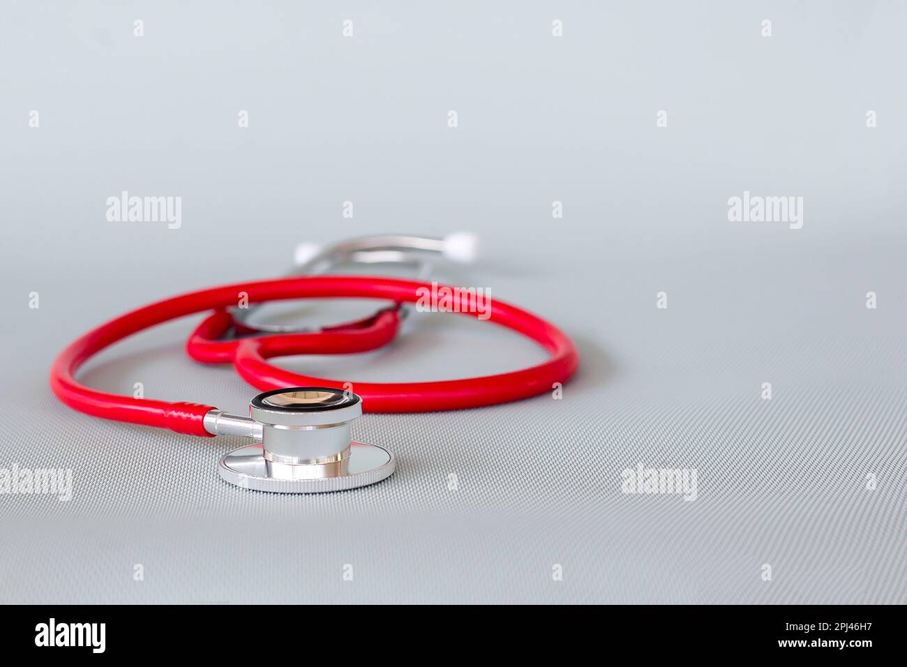 Rotes Stethoskop auf blauem Hintergrund, Gesundheitskonzept. Stockfoto