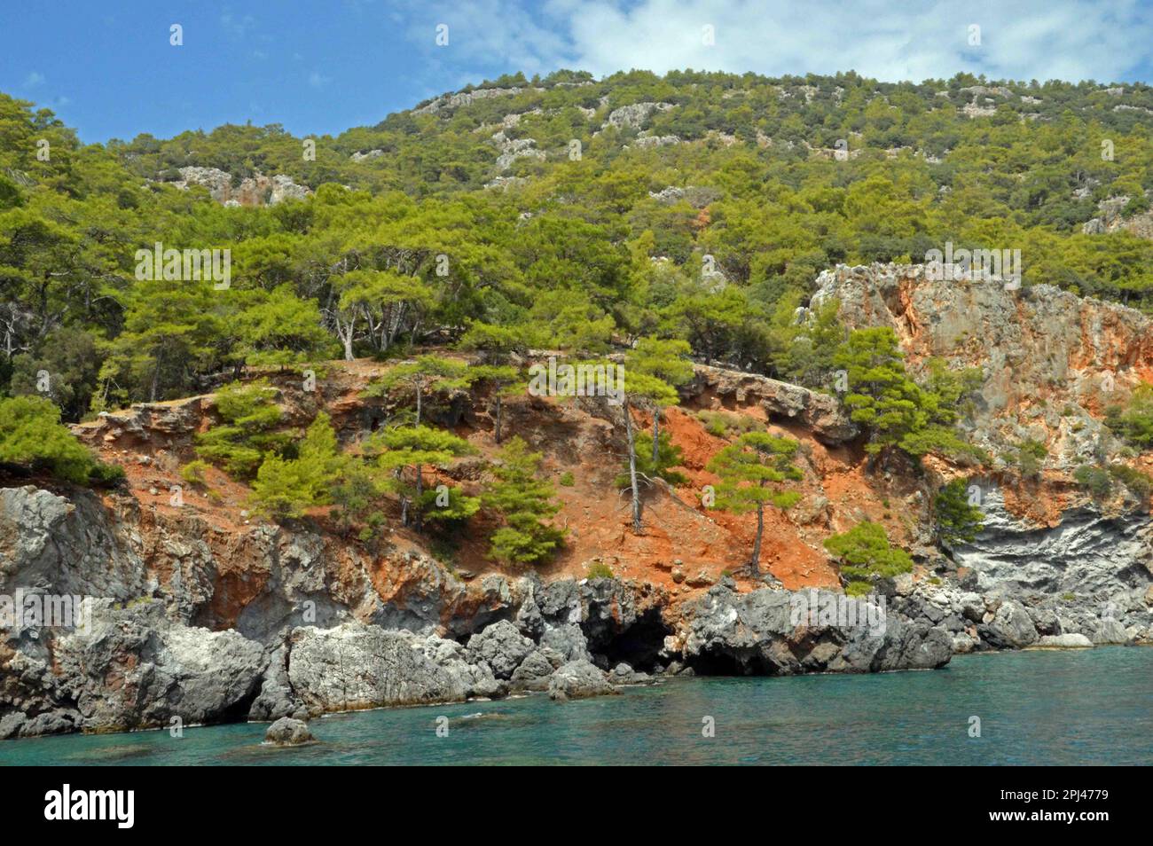 Türkei, Antalya, Lycia: Der winzige Strand, das türkisfarbene Wasser und die lebhaften Klippen der Asikoy Bay, die eine reiche Unterwasserwelt hat. Stockfoto