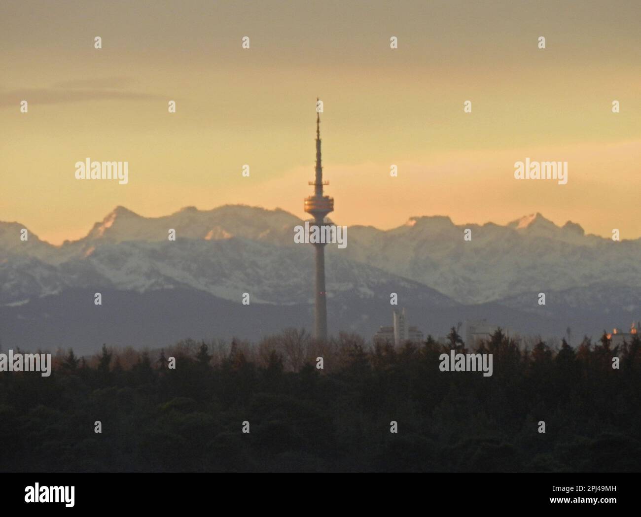 Deutschland, Oberbayern, Unterschleissheim: Die Alpen und die Zugspitze, aus ca. 100 km Entfernung, bei Sonnenuntergang, mit Münchens Olympiaturm Stockfoto