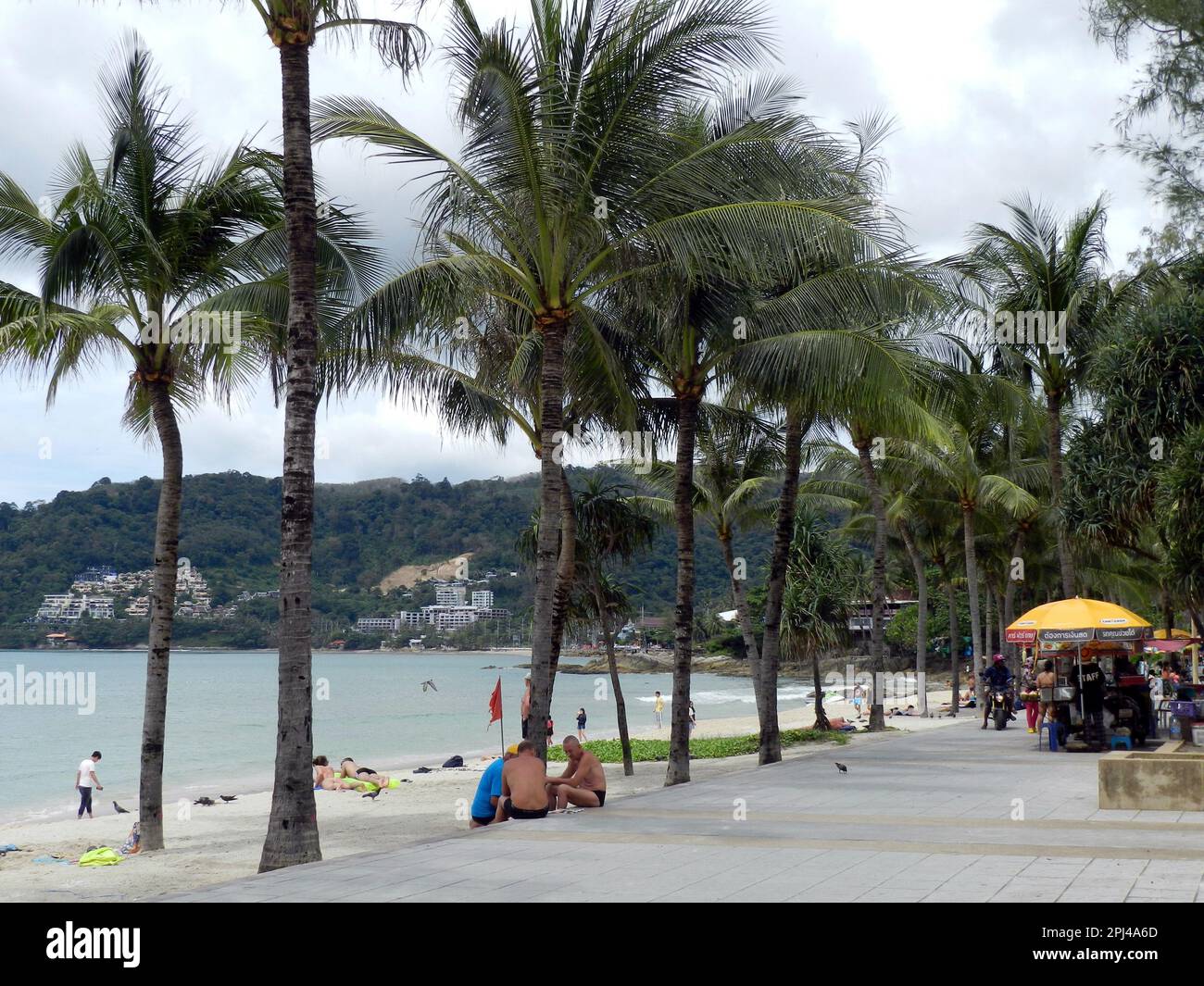 Thailand, Phuket Island, Patong Beach: Die von Palmen gesäumte Promenade, der Sandstrand und Hotels auf der anderen Seite der Bucht. Stockfoto