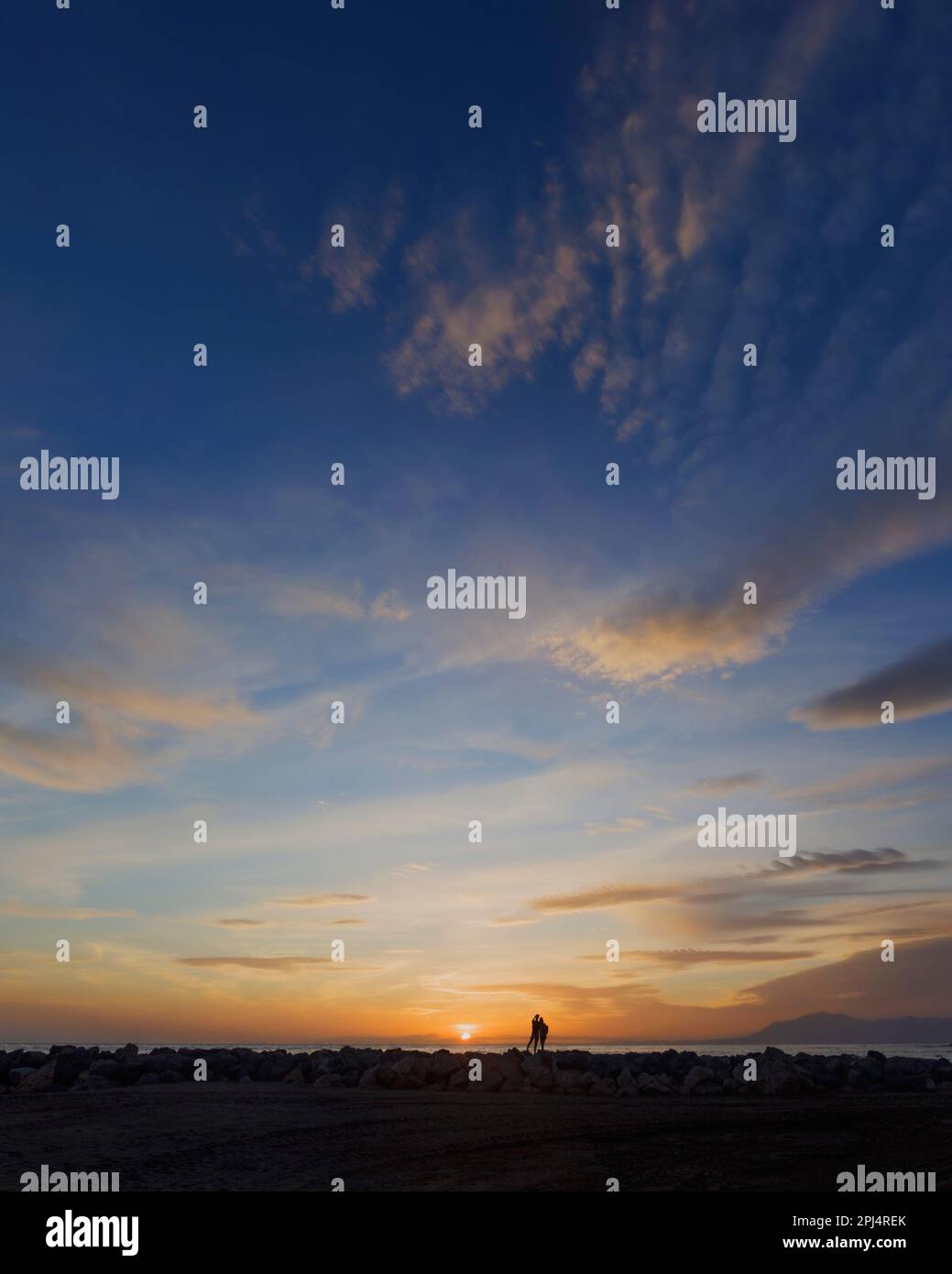 Zwei Menschen beobachten den Sonnenuntergang in der Nähe von Marbella, Provinz Malaga, Costa del Sol, Andalusien, Spanien. Stockfoto