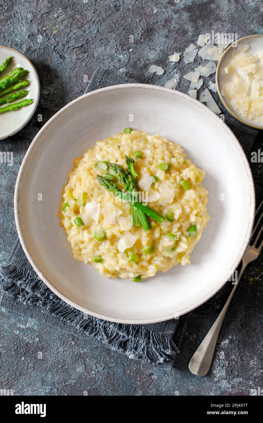 Italienisches Risotto mit Spargel und Parmesankäse auf dem Tisch. Draufsicht. Stockfoto