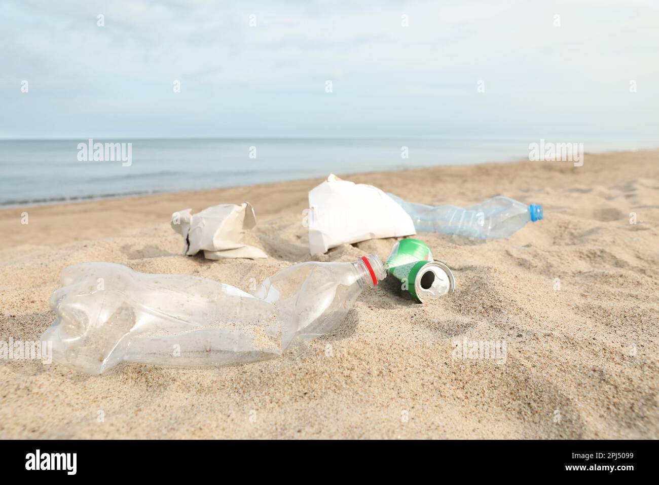 Müll verstreut am Strand in der Nähe des Meeres. Recycling-Problem Stockfoto
