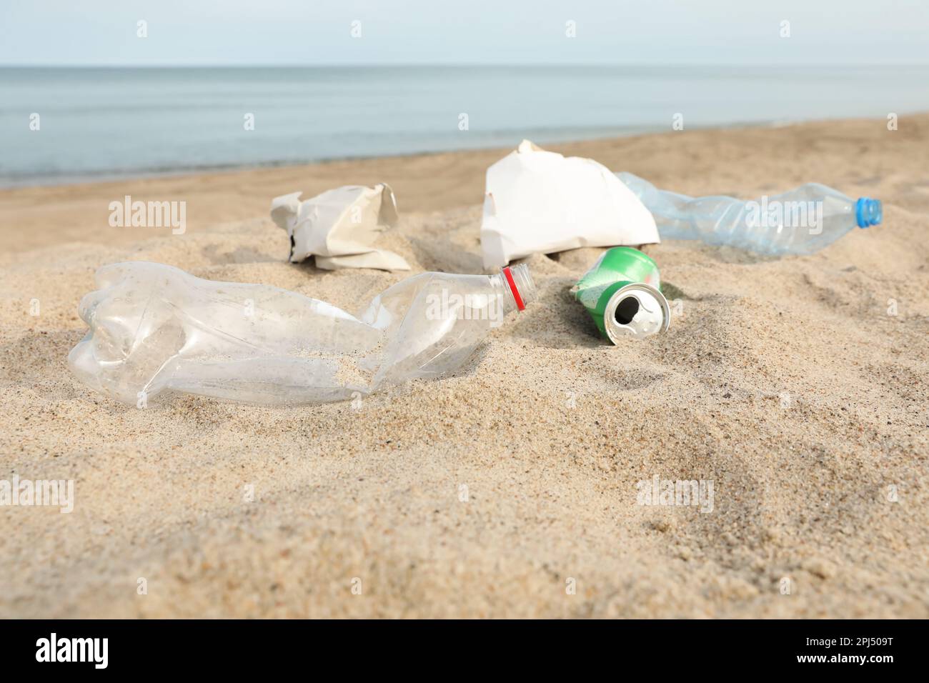 Müll verstreut am Strand in der Nähe des Meeres. Recycling-Problem Stockfoto