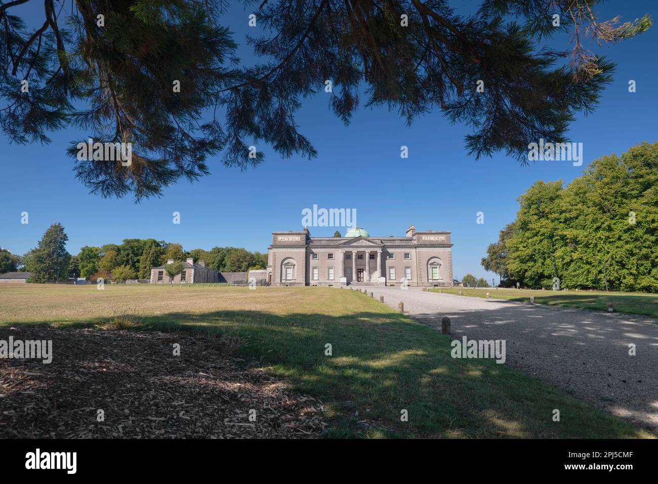 Irland, County Laois, Emo Court, die Fassade des Hauses, eingerahmt von überhängenden Ästen, ist Emo Court ein typisch neoklassizistisches Herrenhaus Stockfoto