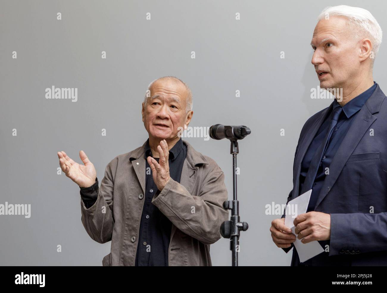 Berlin, Deutschland. 31. März 2023. Klaus Biesenbach (r), Direktor der Neuen Nationalgalerie, steht neben dem in Taiwan geborenen US-Künstler Tehching Hsieh in der Ausstellung „One Year Performance 1980-1981 (Time Clock piece)“ in der Neuen Nationalgalerie. Die Ausstellung ist vom 01. April 2023 bis 30. Juli 2023 zu sehen. Die 8627 Selbstporträts, die mit der ersten Ausstellung des Werkmals Hsieh in Deutschland geschaffen wurden. Kredit: Julius-Christian Schreiner/dpa/Alamy Live News Stockfoto