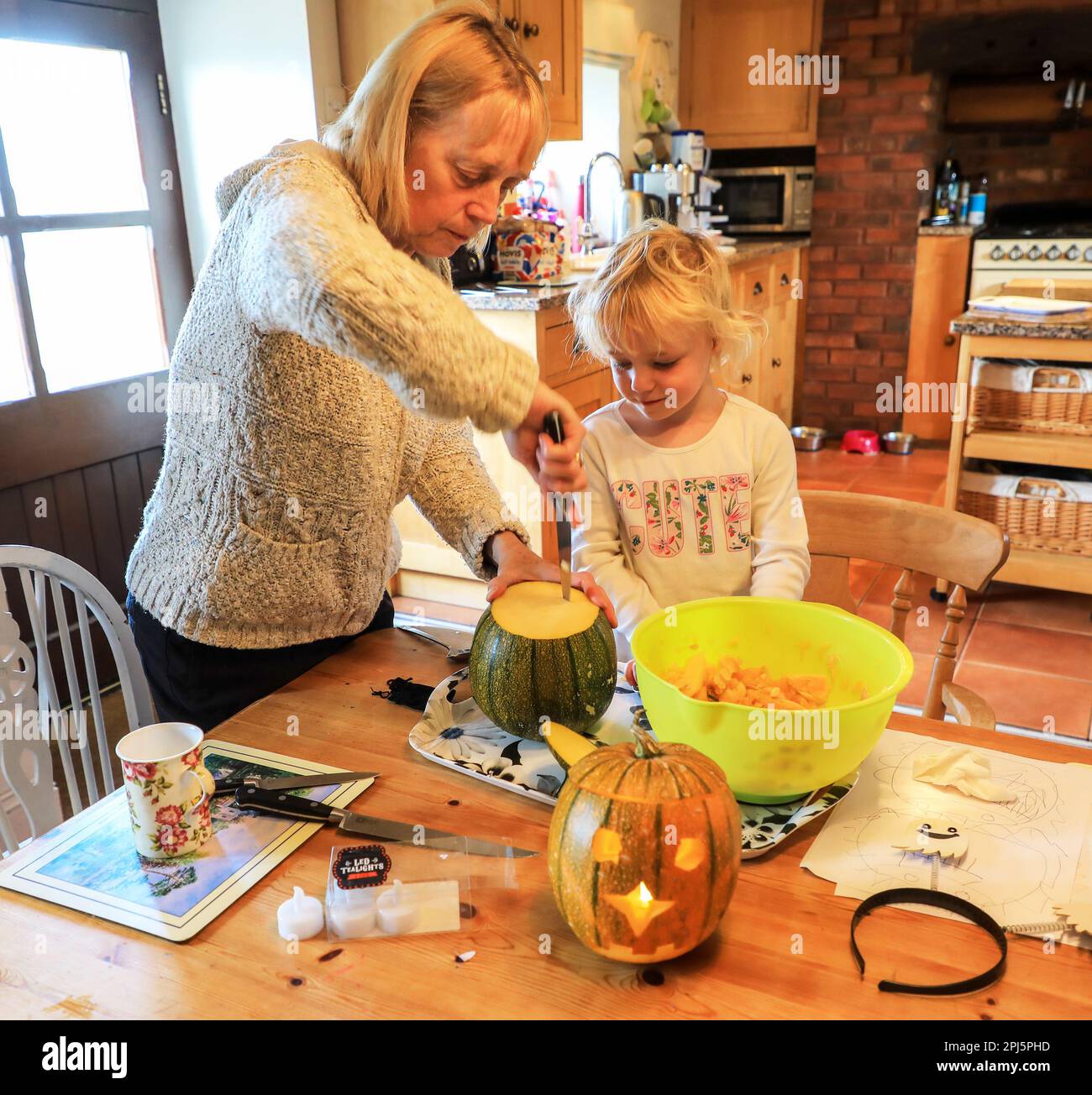 Eine Großmutter und ihre Enkelin machen Kürbislaternen für Halloween, England, Großbritannien Stockfoto