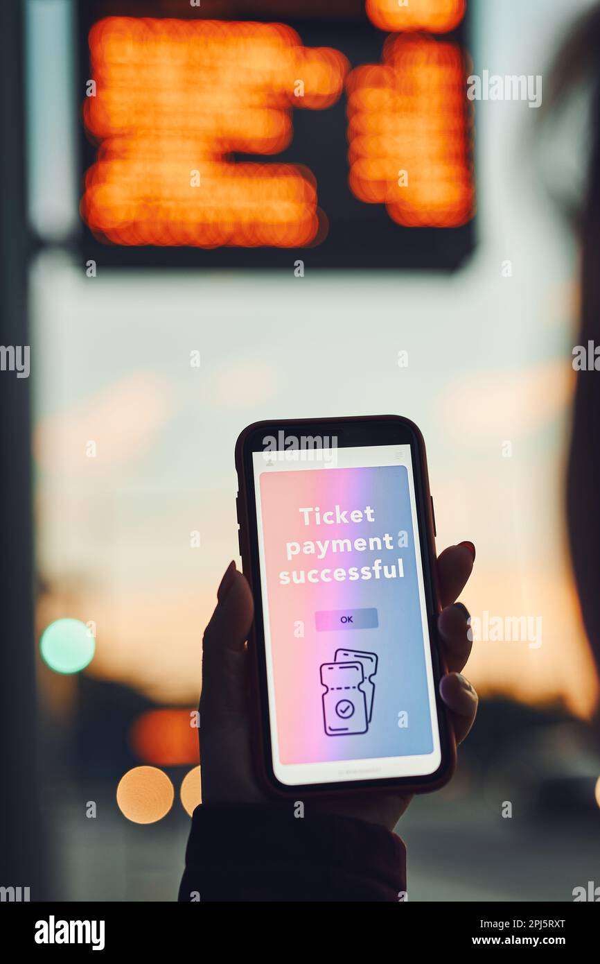 Person, die das Ticket online in der Nähe der Bushaltestelle vor der Fahrt kauft. Person, die das Ticket mit der mobilen Zahlungsanwendung bezahlt. Einsatz von Technologie für unterwegs. Bestätige Stockfoto
