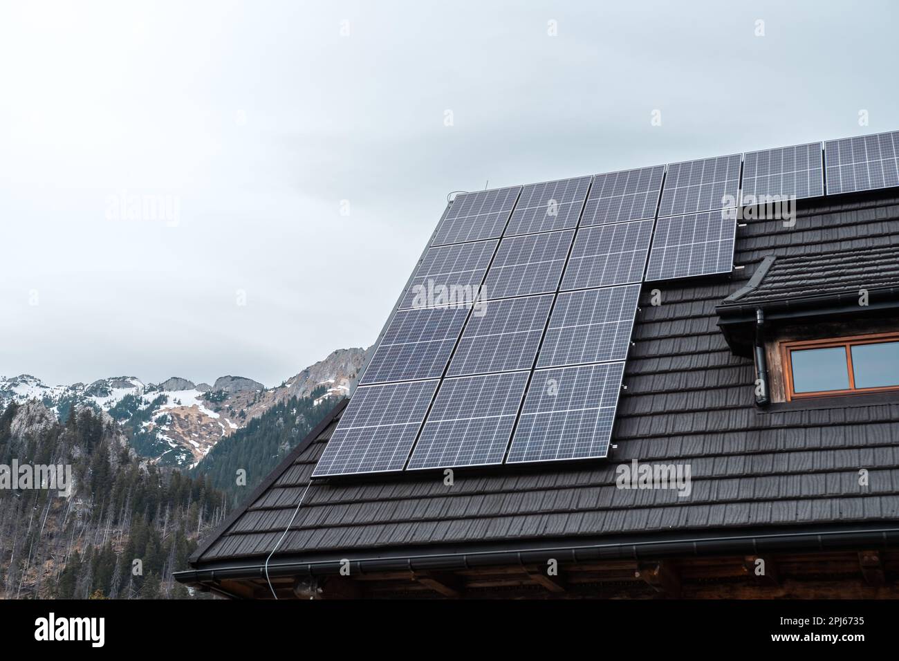 Photovoltaikpaneele auf dem Dach einer Berghütte. Berge im Hintergrund Stockfoto