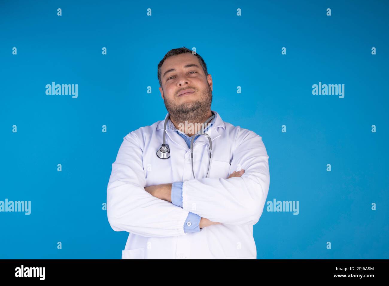 Jugendliches Erwachsenenarztporträt von vorne auf isoliertem blauem Hintergrund. Arztbesuchkonzept Stockfoto