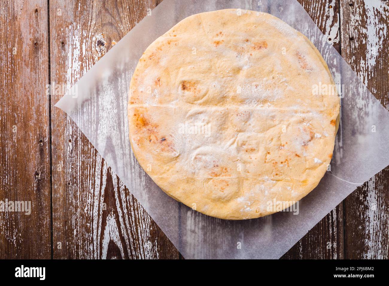 Fladenbrot, Pita oder Pizzabruste auf dem hölzernen Küchentisch Stockfoto